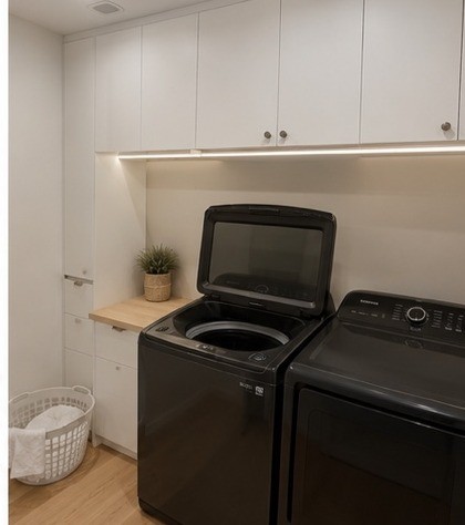 Laundry room with washer and dryer and cabinets